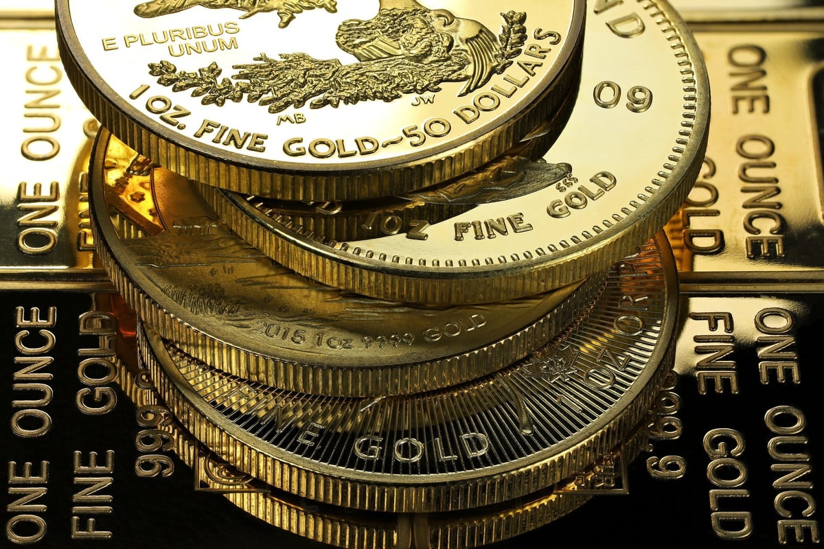 Gold bullion coins resting on a layer of gold ingots