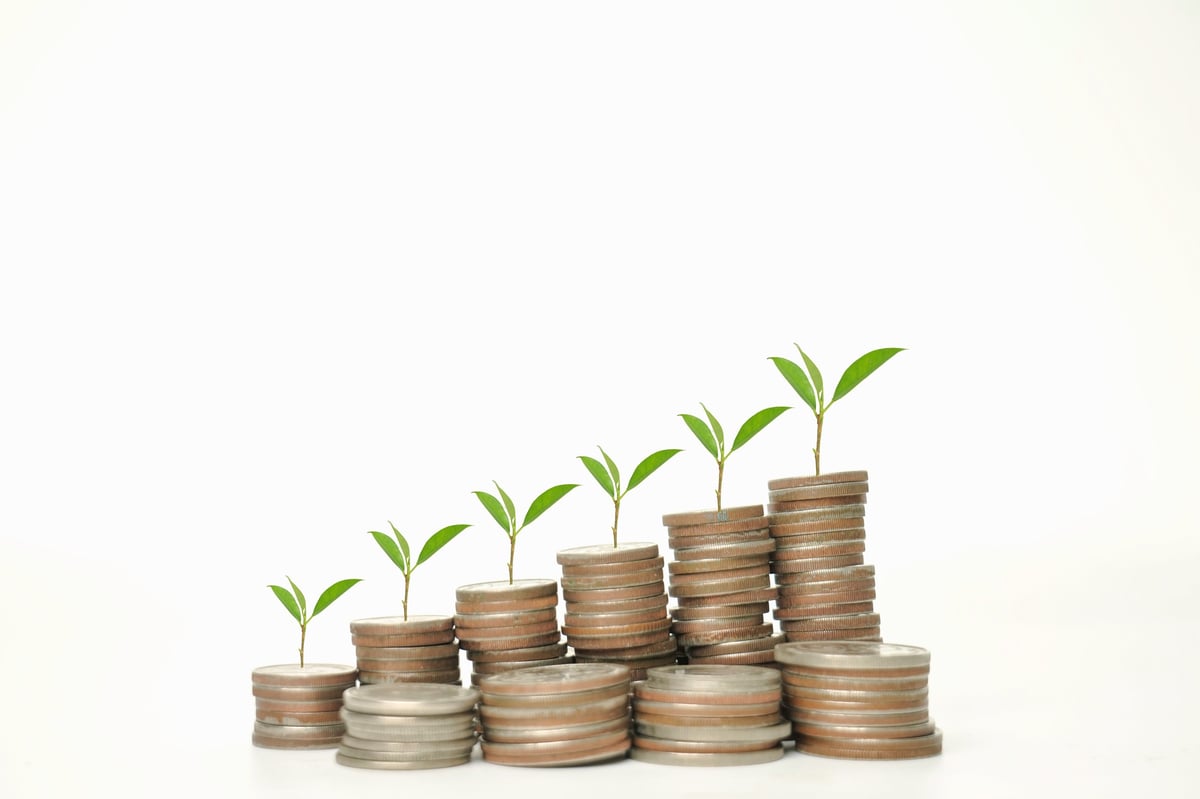Stacks of coins with young green plants growing from them